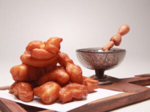 koeksisters with bowl of syrup